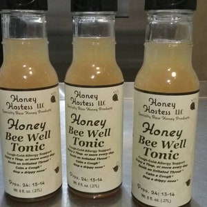 May include: Three glass bottles of honey bee well tonic, a raw honey product from Honey Hostess LLC. Each bottle is labeled with the product name, ingredients, and instructions for use. The bottles are 8 fluid ounces each.