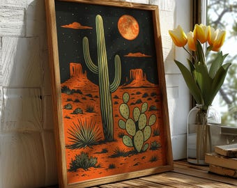 May include: A framed desert landscape art print. The artwork features a night scene with a large cactus, a full moon, and desert rock formations. The color palette includes orange, black, and green tones. The frame is made of wood.