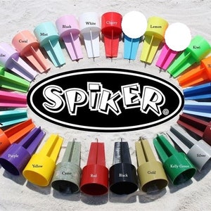 May include: A variety of colorful sand-filled drink holders, called "Spikers", are arranged in a circle on a sandy beach. The holders are made of plastic and have a variety of colors, including red, blue, green, yellow, orange, purple, pink, white, and black. The holders are labeled with their corresponding colors.