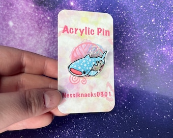 May include: A blue and pink whale shark acrylic pin with white polka dots. The pin is on a white card with the text "Acrylic Pin" and "Nessiknacks0301".