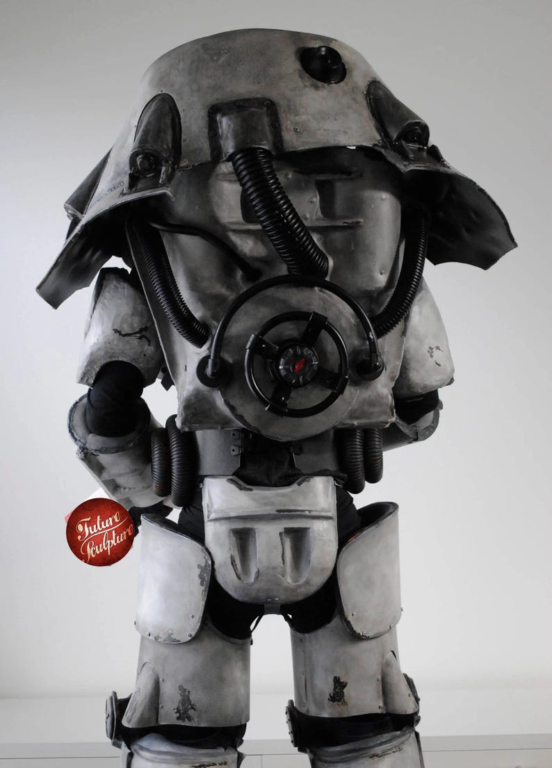 May include: A gray and black power armor suit with a large, round, black air filter on the chest. The suit has a large, gray helmet with a black visor. The suit is standing on a white background.