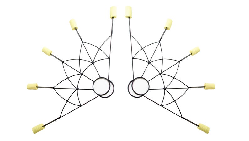May include: Pair of black fire fans with a geometric design. Each fan features a circular handle and multiple spokes ending in yellow wicks. The fans are symmetrical and designed for performance or entertainment.