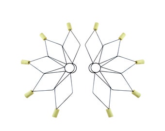 May include: A pair of black metal fire poi with eight yellow fire wicks attached to the ends of the spokes.