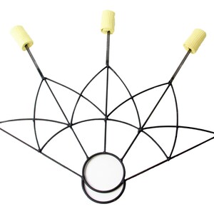 May include: A black metal fire fan with six wicks. The fan has a geometric design with a circular handle. The wicks are cylindrical and yellow. The fan is designed for fire performance.