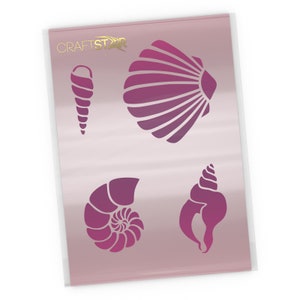 May include: A sheet of reusable plastic stencil with four different seashell designs. The designs are a scallop shell, a spiral shell, a conch shell, and a nautilus shell. The stencil is pink and white.