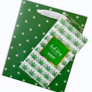 May include: Green gift bag with a white leaf pattern. The bag is paired with a sheet of green leaf patterned tissue paper that says "Kush Wrap" and "kushkards" in gold lettering.