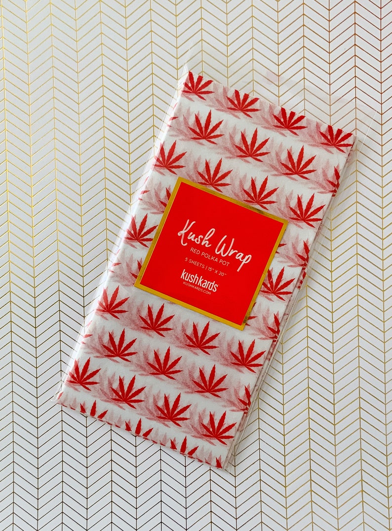 K&ouml;nnte beinhalten: Eine Packung rotes Kush Wrap Seidenpapier mit Punkten und einem roten Etikett mit der Aufschrift "Kush Wrap Red Polka Pot 5 Sheets 15" x 20" kushkards kushkards.com"