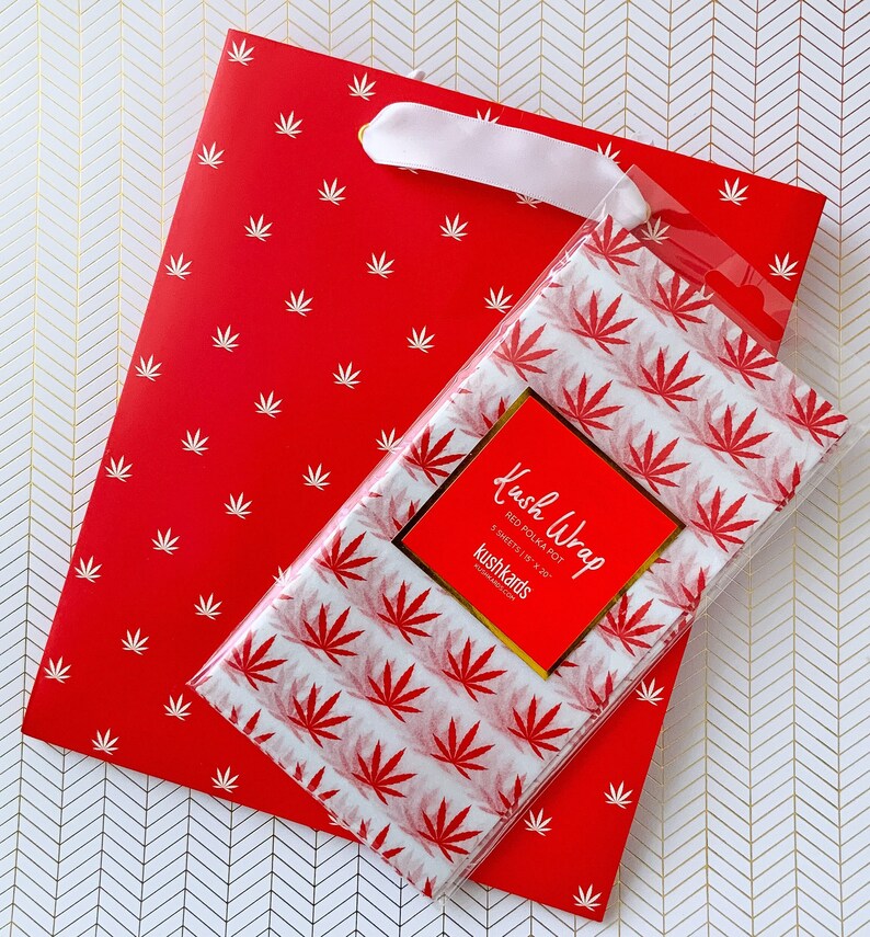 K&ouml;nnte beinhalten: Rote Geschenkt&uuml;te mit wei&szlig;em Blatt-Muster und ein wei&szlig;es Seidenpapier mit rotem Blatt-Muster und dem Text "Kush Wrap Red Polka Pot 5 Sheets 15 x 20 Kushkards"