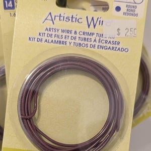May include: A package of Artistic Wire in a deep purple color. The package includes 3 feet of 14 gauge wire, approximately 1.6 mm in diameter. The package also includes crimp tubes. The text "Artistic Wire" is printed on the package.