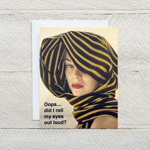 May include: A woman wearing a black and yellow striped scarf with the text "Oops... did I roll my eyes out loud?"