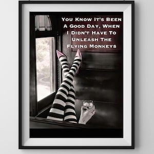 May include: A black and white image of a woman's legs in striped stockings and pink heels. The woman is sitting in a chair with a glass of liquid in her hand. The text "You know it's been a good day, when I didn't have to unleash the flying monkeys" is written in white on a dark background.