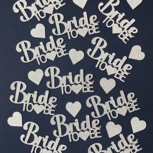 May include: Silver glitter confetti with the words "Bride to Be" and hearts.