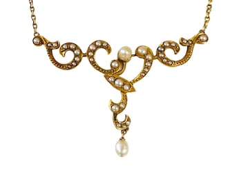 May include: A delicate gold necklace with a pendant featuring a floral design accented with pearls.