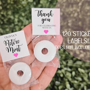 May include: A set of 120 white sticker labels with the text "Olivia's Retire Mint" and a pink heart. The labels are designed for small round mints. The text "120 STICKER LABELS! DOES NOT INCLUDE MINTS" is also visible.