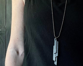 Stylized black leather pendant necklace on EKORCE chain
