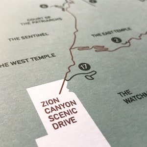 Op de afbeelding: Een kaart van de Zion Canyon Scenic Drive met de route in bruin gemarkeerd. De kaart bevat bezienswaardigheden zoals The Sentinel, The West Temple, The East Temple en The Watchman.