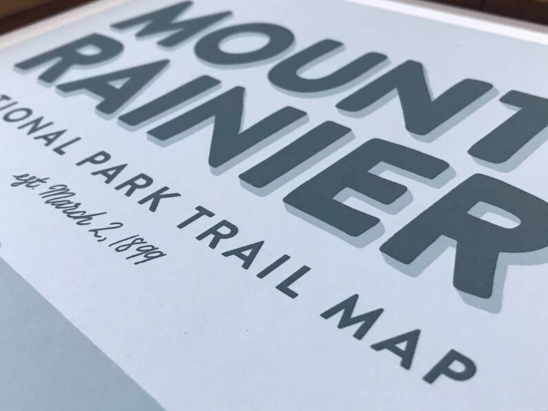 May include: A blue and white vintage-style poster with the text "Mount Rainier National Park Trail Map" and the date "Sept. March 2, 1899".
