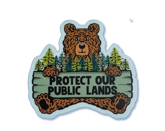 May include: A brown bear with a green forest background holding a sign that says "Protect Our Public Lands".
