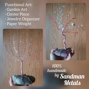 May include: Two handmade wire trees with a twisted wire trunk and curled wire branches. The trees are on a stone base. The text "100% handmade by Sandman Metals" is at the bottom of the image.