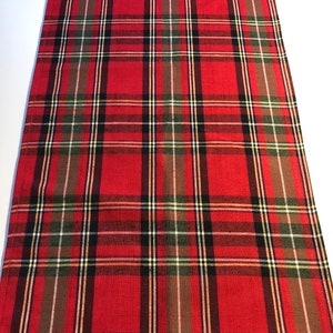 May include: Red, black, green, and white plaid table runner. The runner has a woven texture.