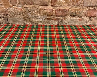 May include: Red, green, and yellow plaid tablecloth. The tablecloth is made of a woven fabric and has a checkered pattern.
