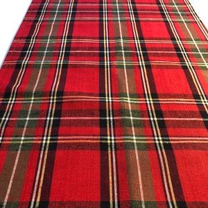 May include: Red, green, black, and white plaid table runner. The runner has a woven texture.