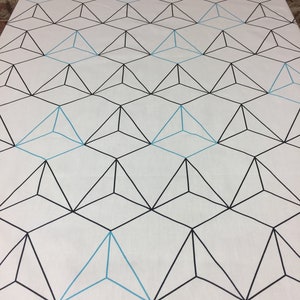 Peut inclure: Tissu blanc avec un motif géométrique de triangles noirs et bleu clair.