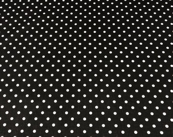 May include: Black fabric with a white polka dot pattern.
