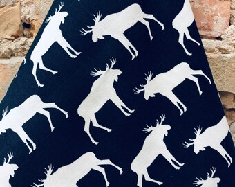 May include: A black fabric with a white moose silhouette pattern. The moose are facing each other and are in a repeated pattern.