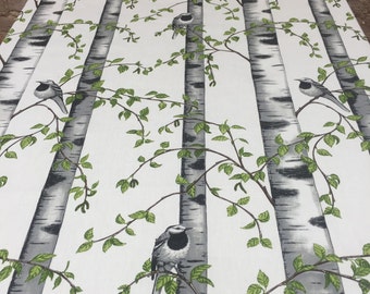 May include: White fabric with a repeating pattern of birch trees and small black and white birds. The trees have a gray bark with black markings and green leaves.