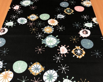 Könnte beinhalten: Schwarzer Tischläufer mit einem Retro-Design im Stil der Mitte des Jahrhunderts, mit weißen, rosa, goldenen und türkisfarbenen geometrischen Formen und Sternen.