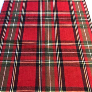 May include: Red, green, black, and white plaid table runner. The runner has a woven texture.