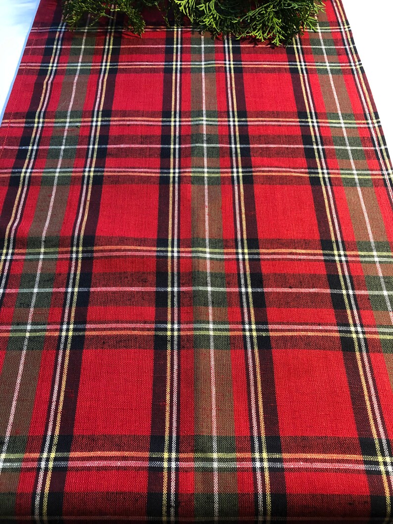 May include: Red, green, black, and white plaid table runner. The runner has a woven texture.