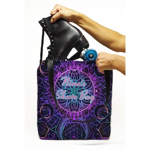 Può includere: Una borsa tote viola, blu e nera con un design a mandala e il testo "Nina's Skate Bag". Una persona sta mettendo un pattino nero nella borsa.
