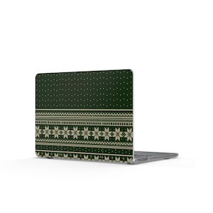 Könnte beinhalten: Eine dunkelgrüne Laptop-Hülle mit einem cremefarbenen Fair-Isle-Muster aus sich wiederholenden geometrischen Formen, horizontalen Streifen und sternartigen Motiven auf der Rückseite, angebracht an einem silbernen Laptop mit Tastatur.