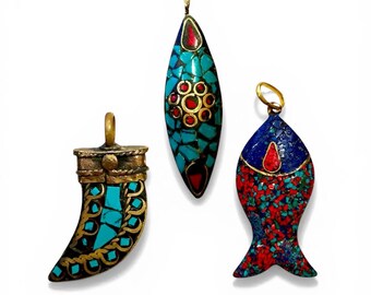 May include: Three handcrafted pendants with turquoise, red, and gold accents. One is horn-shaped, another is an elongated oval, and the third is fish-shaped. Each pendant has a gold-colored bail for hanging.