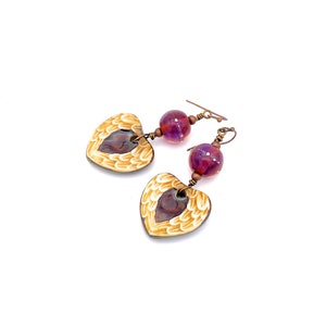 Earrings made with a heart-shaped charm featuring 2 angel wings in shades of cream with maroon in the center hang below matching maroon handmade lampwork glass beads.  Hand wrapped with copper wire.  Copper ear wires.