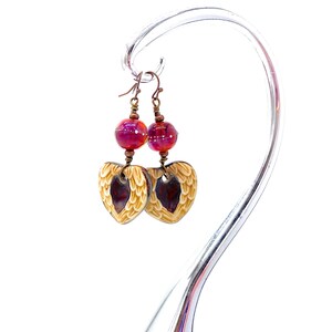 Earrings made with a heart-shaped charm featuring 2 angel wings in shades of cream with maroon in the center hang below matching maroon handmade lampwork glass beads.  Hand wrapped with copper wire.  Copper ear wires.