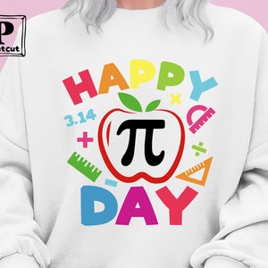May include: White sweatshirt with a colorful graphic design that says "Happy Pi Day". The graphic includes a red apple with a black pi symbol, colorful numbers, plus signs, and protractors.