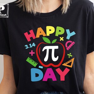 May include: Black t-shirt with a colorful graphic that says "Happy Pi Day" with a red apple with a white pi symbol inside. The graphic also includes colorful math symbols like plus signs, minus signs, and a protractor.