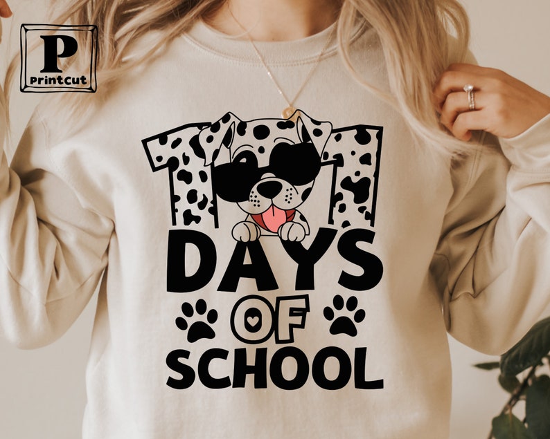 K&ouml;nnte beinhalten: Ein wei&szlig;es Sweatshirt mit einer schwarzen Grafik eines Dalmatiners mit Sonnenbrille und dem Text "101 Tage Schule".