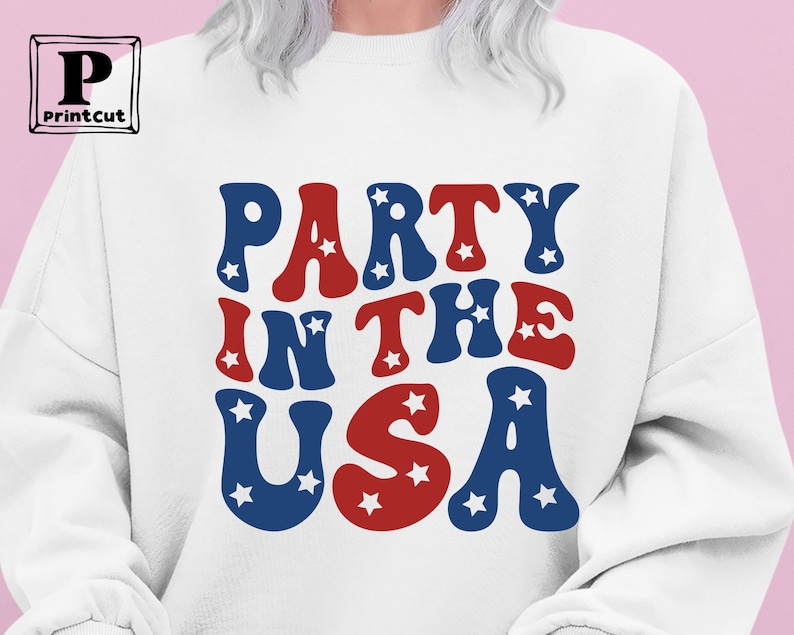 May include: White sweatshirt with the text "Party in the USA" in red, white, and blue with stars.