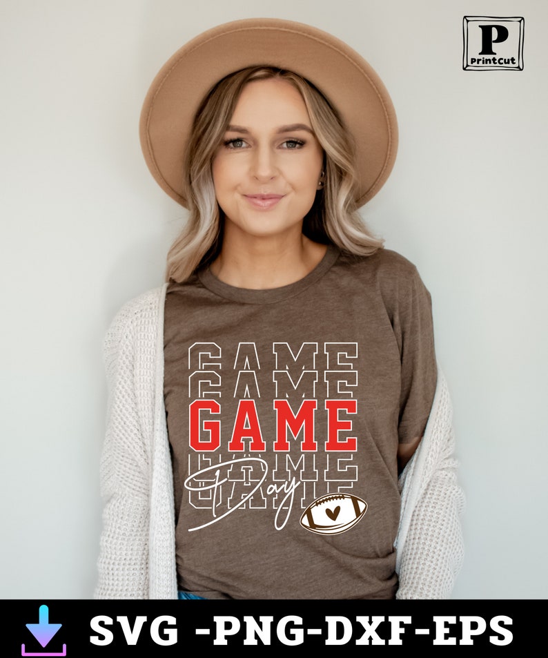 May include: A brown t-shirt with the text "GAME DAY" in white and red letters. The text is stacked on top of itself with the word "GAME" in red. A brown and white football with a red heart is below the text.