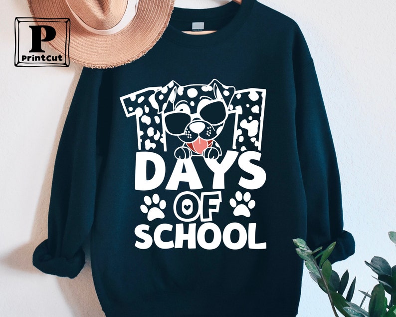 K&ouml;nnte beinhalten: Schwarzes Sweatshirt mit einer wei&szlig;en Grafik eines Dalmatiners mit Sonnenbrille und dem Text "101 Tage Schule".