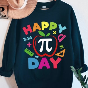 May include: A black sweatshirt with a colorful graphic design that says "Happy Pi Day" with a red apple with a white pi symbol inside. The graphic also includes colorful math symbols like plus signs, minus signs, and rulers.