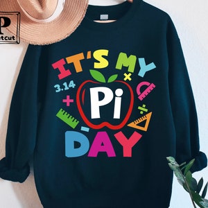 May include: A black sweatshirt with a colorful graphic that says "It's My Pi Day" with a red apple with a white "Pi" inside and colorful math symbols around it.