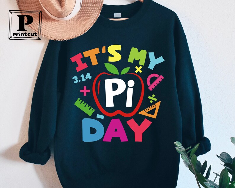 May include: A black sweatshirt with a colorful graphic that says "It's My Pi Day" with a red apple with a white "Pi" inside and colorful math symbols around it.