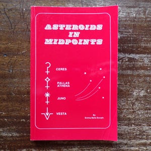 May include: A red book titled "Asteroids in Midpoints" with white text and symbols. The book features the names Ceres, Pallas Athena, Juno, and Vesta.