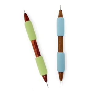 Peut inclure: Deux outils en bois avec des pointes pointues et des poignées en mousse. Un outil a une poignée bleu clair et l'autre une poignée vert clair.