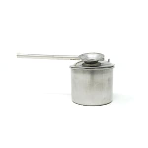 May include: A silver metal container with a long spout and a lid. The container is used for making traditional Indian chai.